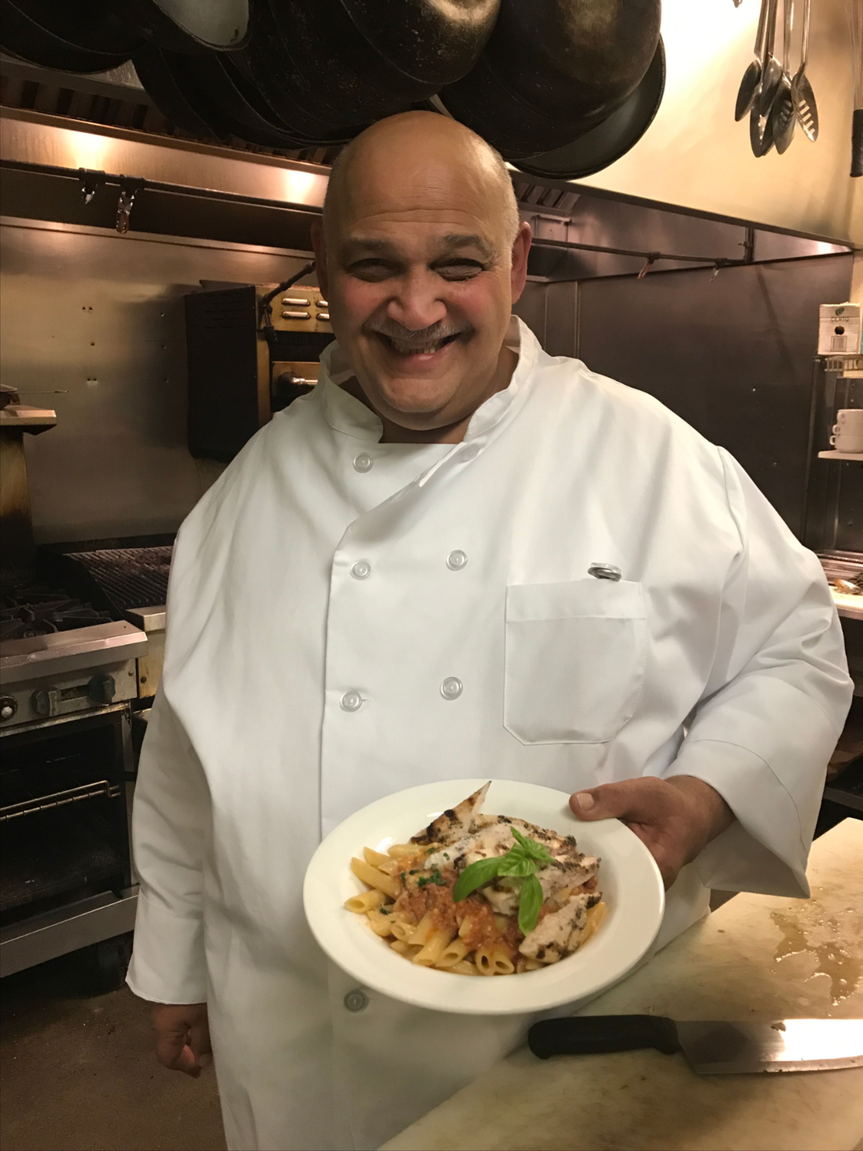 mike smiling and holding a dish with food